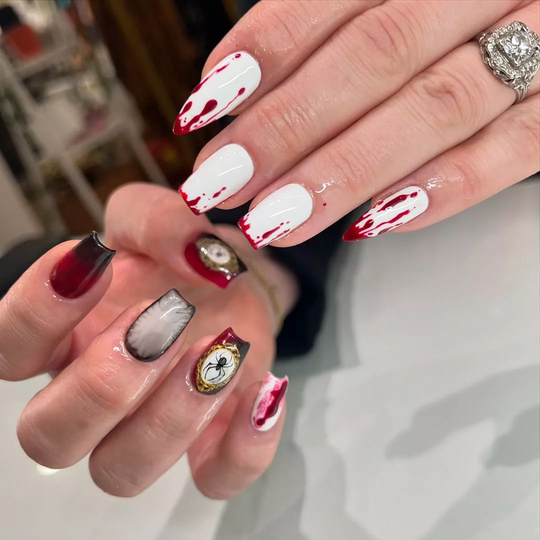 Person showing off their Halloween-inspired nails, which are red, black, and white