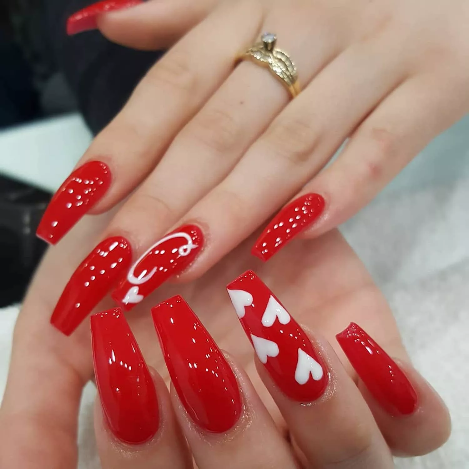 Glossy red Valentine’s Day manicure with heart details