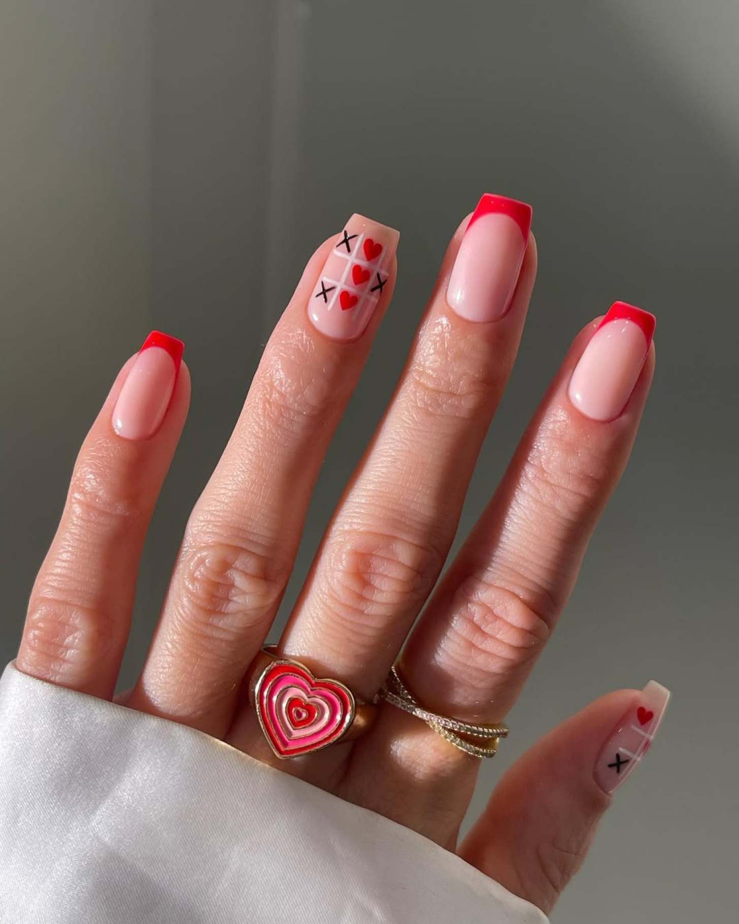 Red French manicure with tic-tac-toe designs