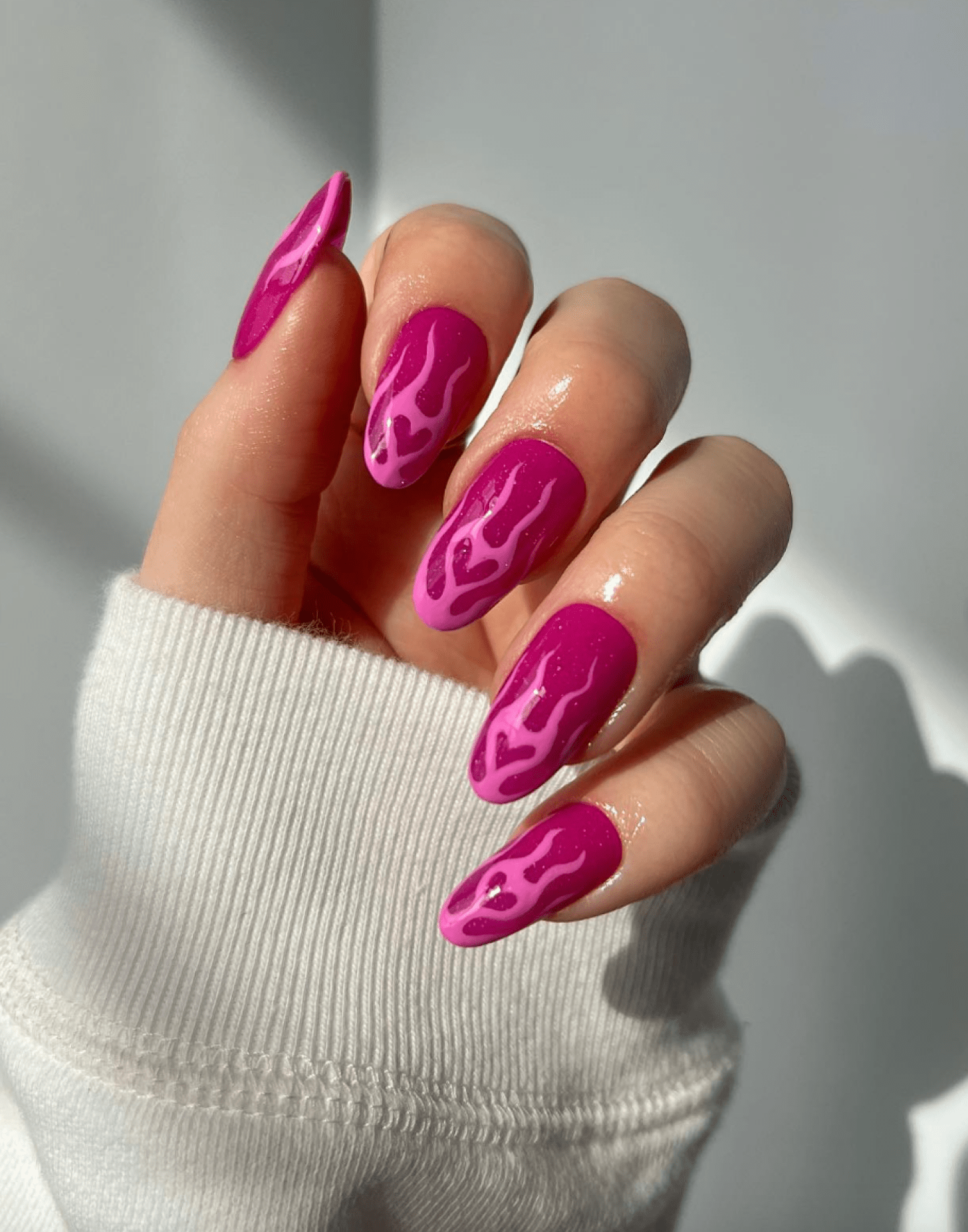 Bright pink nails with flaming heart designs