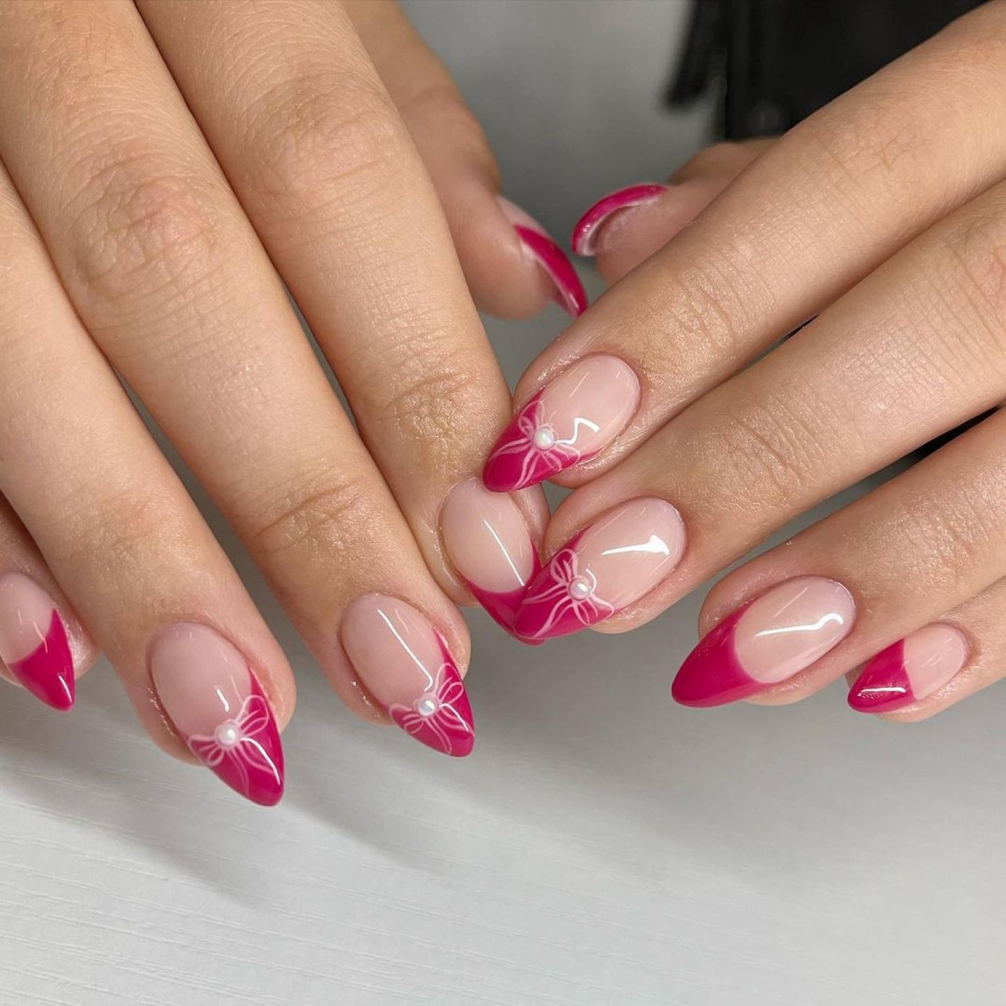 Pink French tips with white bow nail art