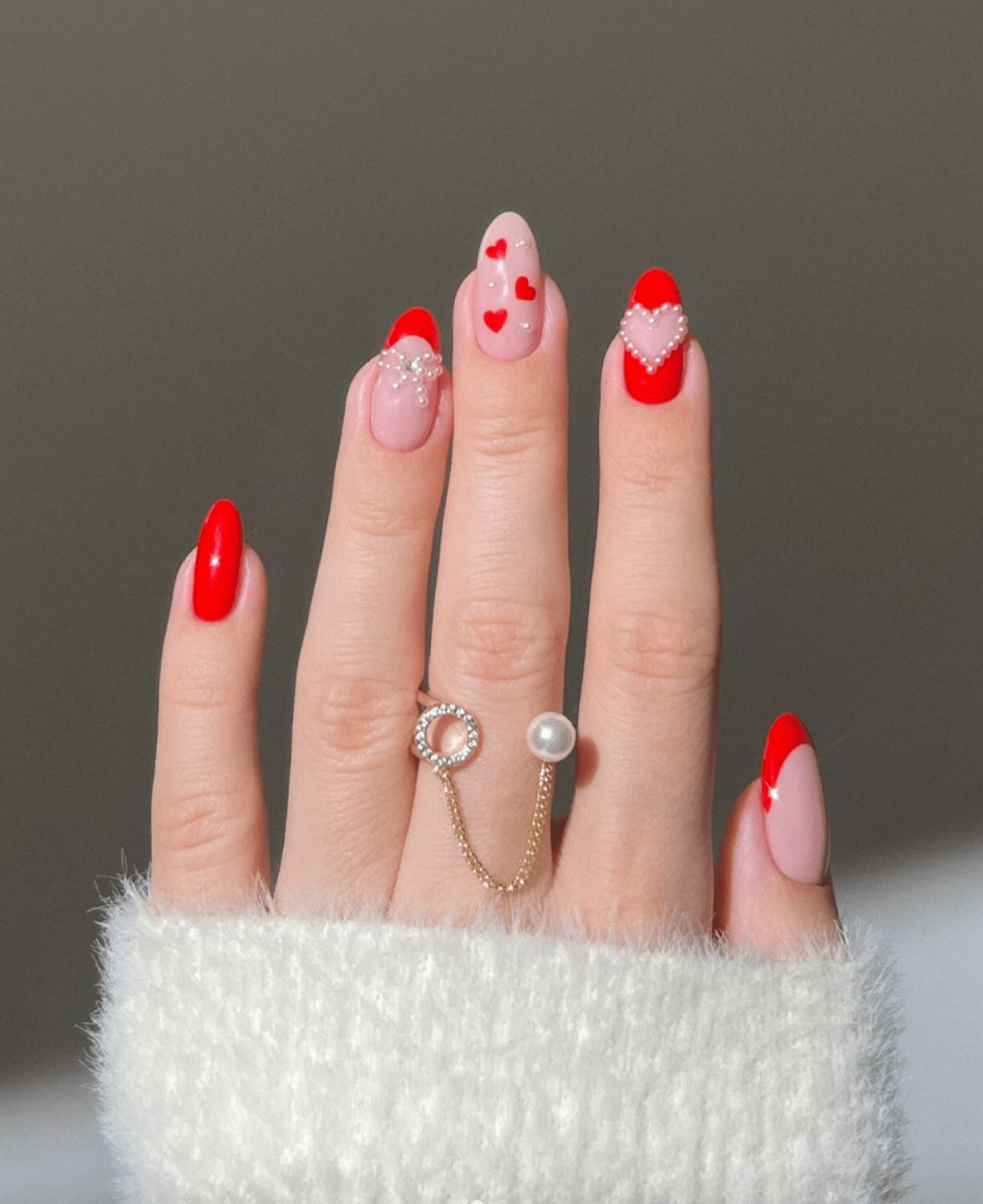 Cute red nails with pearl accents and heart nail art