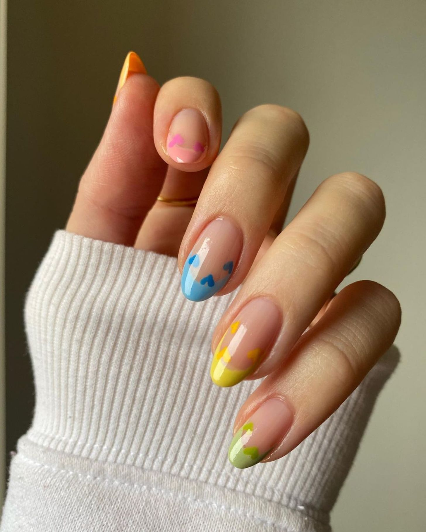 simple skittle Valentine's Day nails with rainbow French tip designs and cute heart nail art