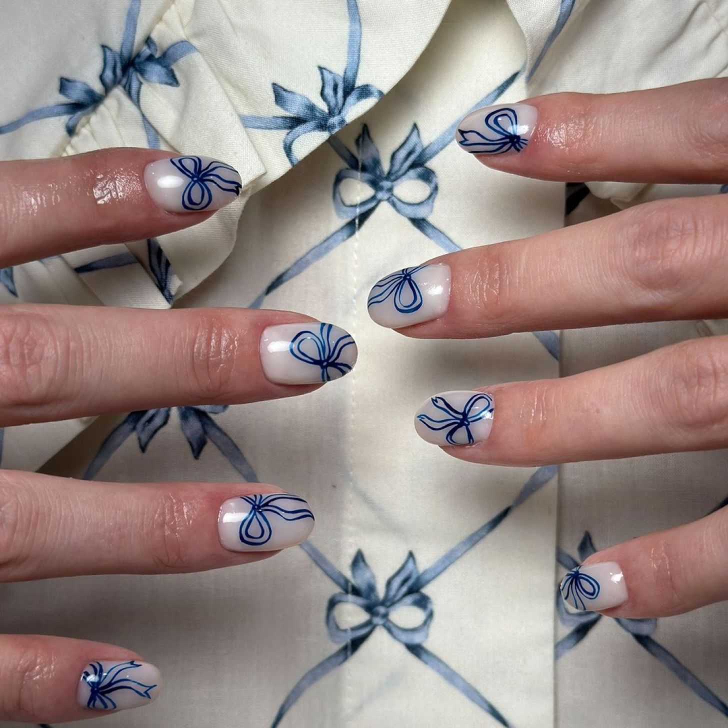 short and simple milky white Valentine's Day nails with cute blue bow outline designs