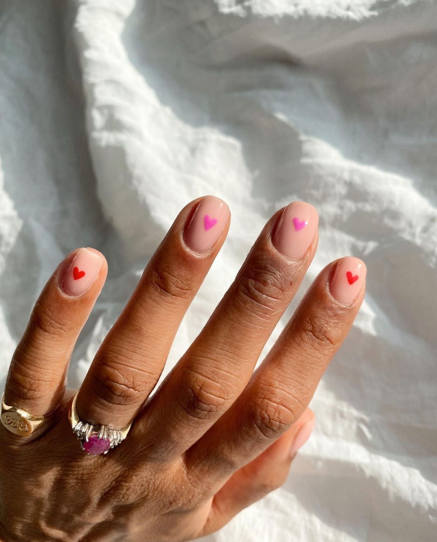 simple nude short Valentines Day nails with cute pink and red heart nail art