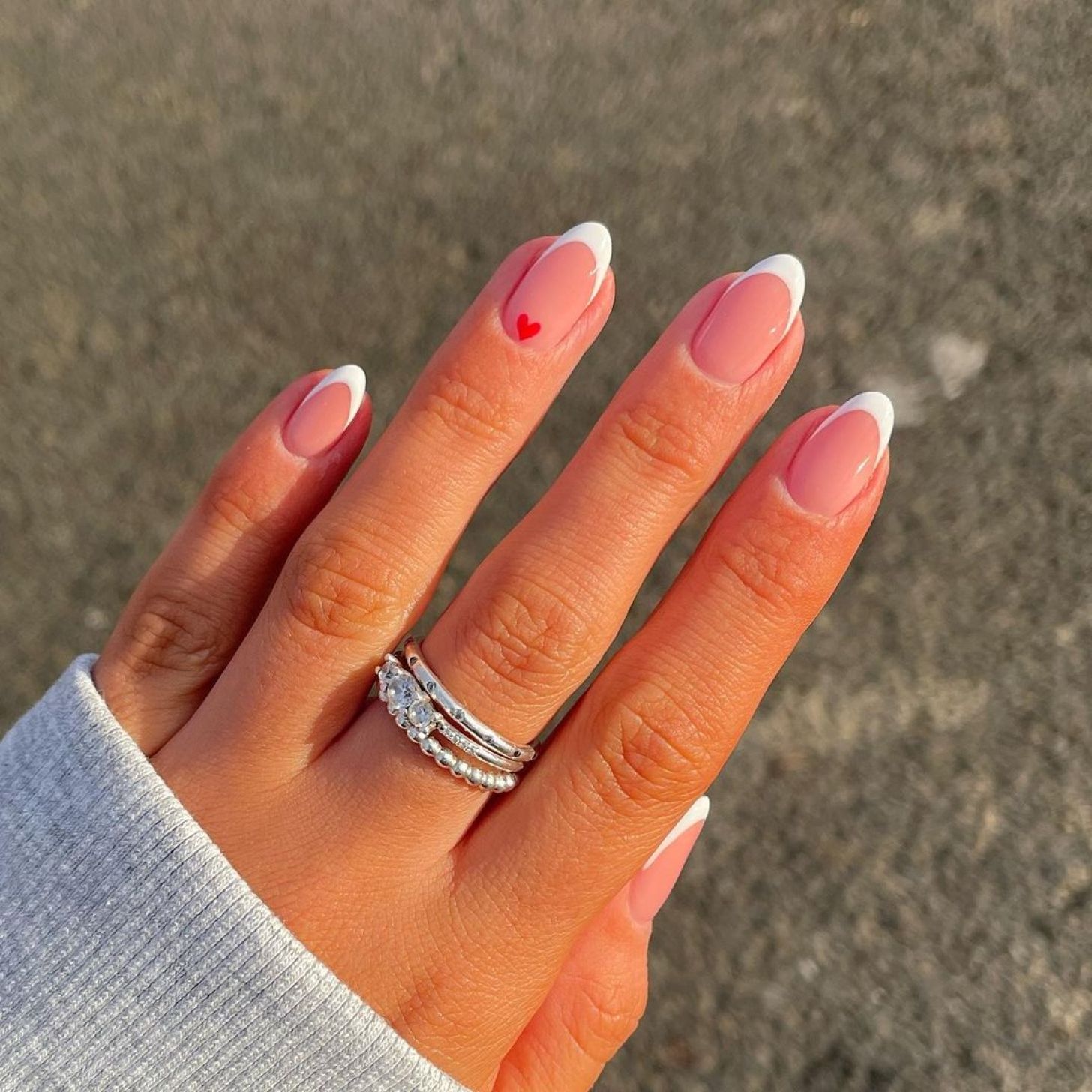 almond shaped white French tip simple Valentine's Day nails with a cute red heart nail art accent design